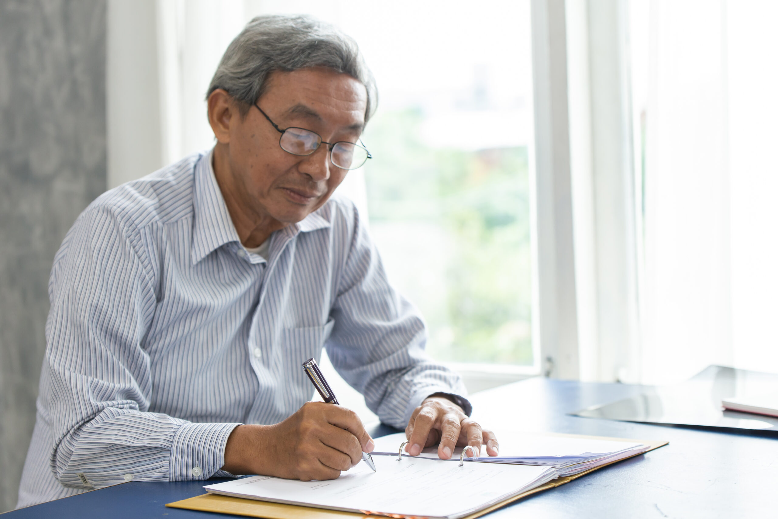 old man writing on a piece of paper