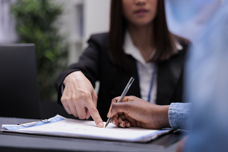 Lawyer guiding a client on signing documents for a letters of administration application.